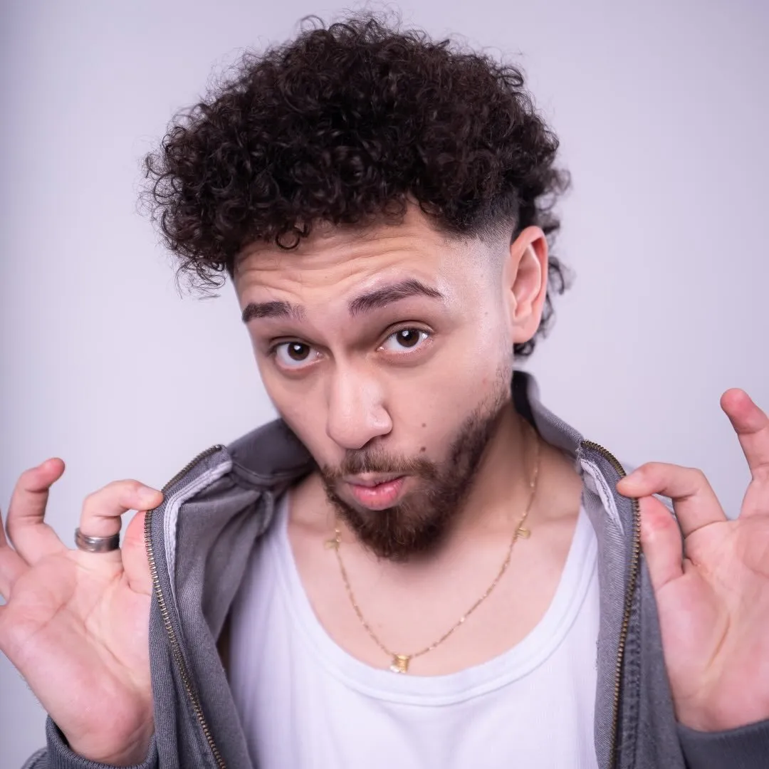 Gio Lisboa é um comediante de stand-up que tem ganhado destaque na cena brasileira com seu humor perspicaz e entrega carismática. Ele é conhecido por sua habilidade em transformar observações do cotidiano em comentários humorísticos, abordando desde peculiaridades do comportamento humano até críticas sociais, tudo com um toque leve e acessível. Gio utiliza sua vivência urbana para conectar-se com públicos de diferentes backgrounds, tornando suas piadas relevantes e inclusivas. Seus shows são bem recebidos por trazerem tanto risadas quanto reflexões, e ele é frequentemente elogiado por sua presença de palco confiante e interação genuína com a plateia.